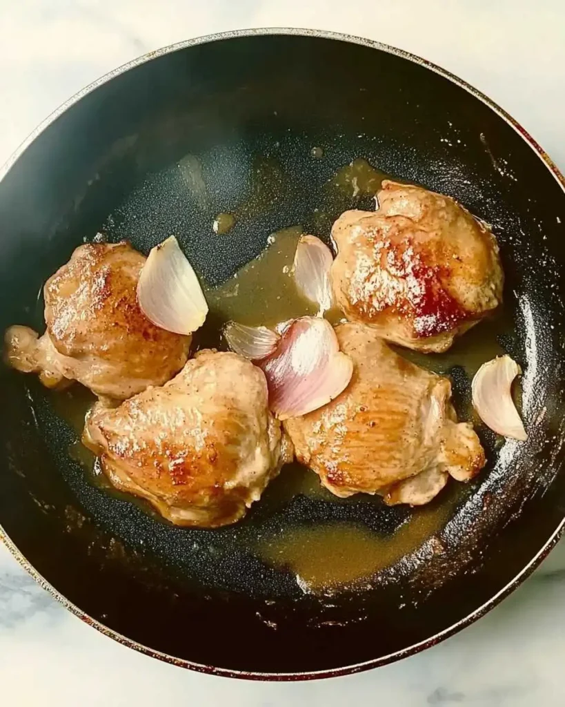 Chicken breasts cooking in teriyaki sauce with garlic