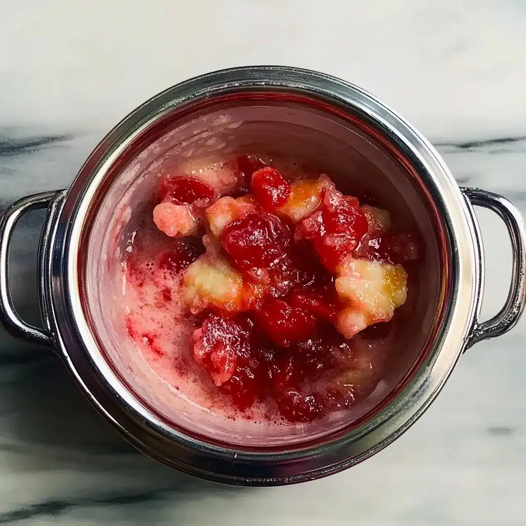 Sliced strawberries and bananas combined in a bowl before blending